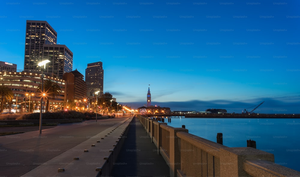 Blick auf eine Stadt bei Nacht von einem Pier aus