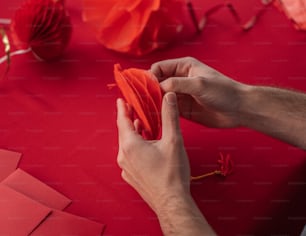 a person holding a piece of red paper