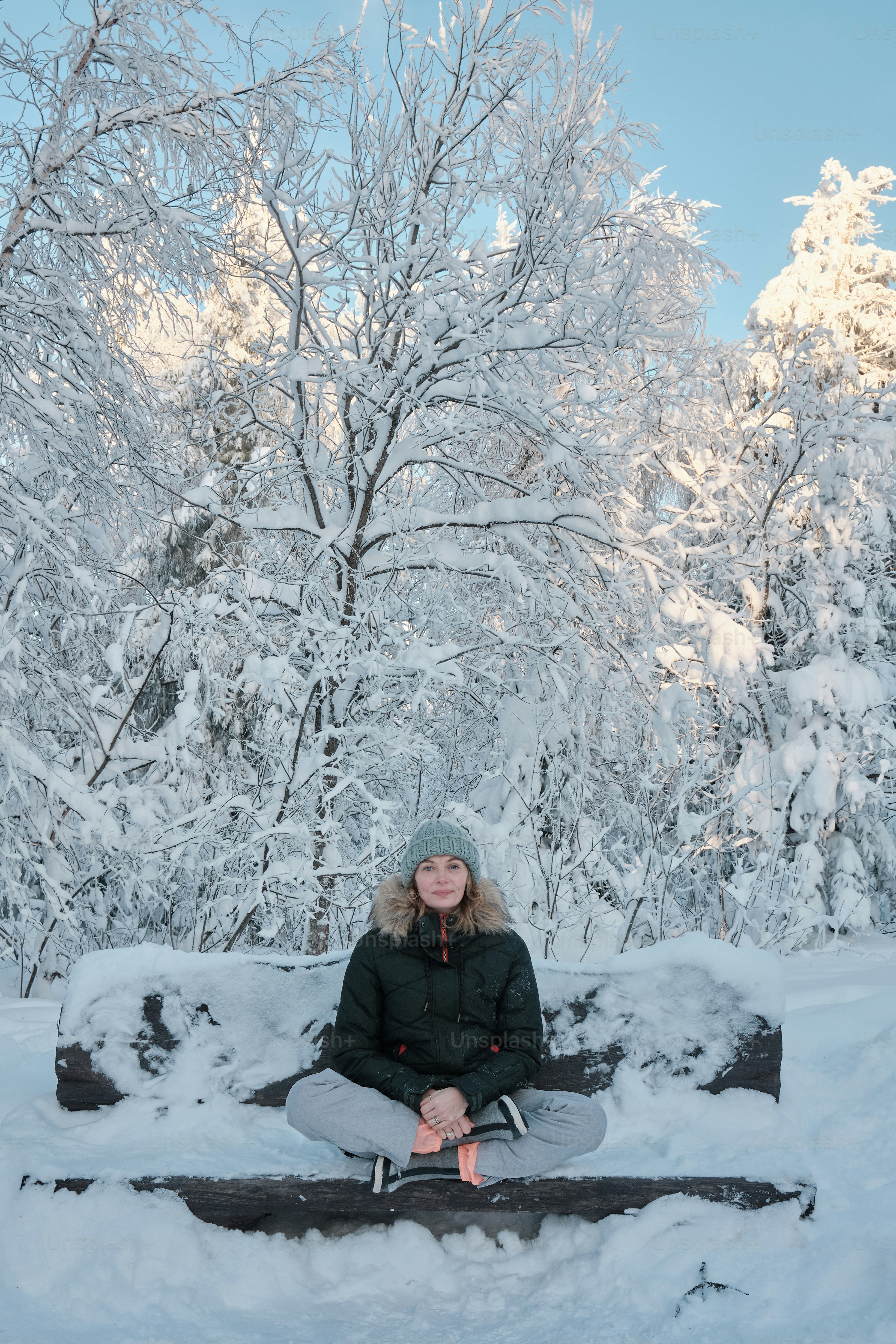 a woman sitting on a bench in the snow