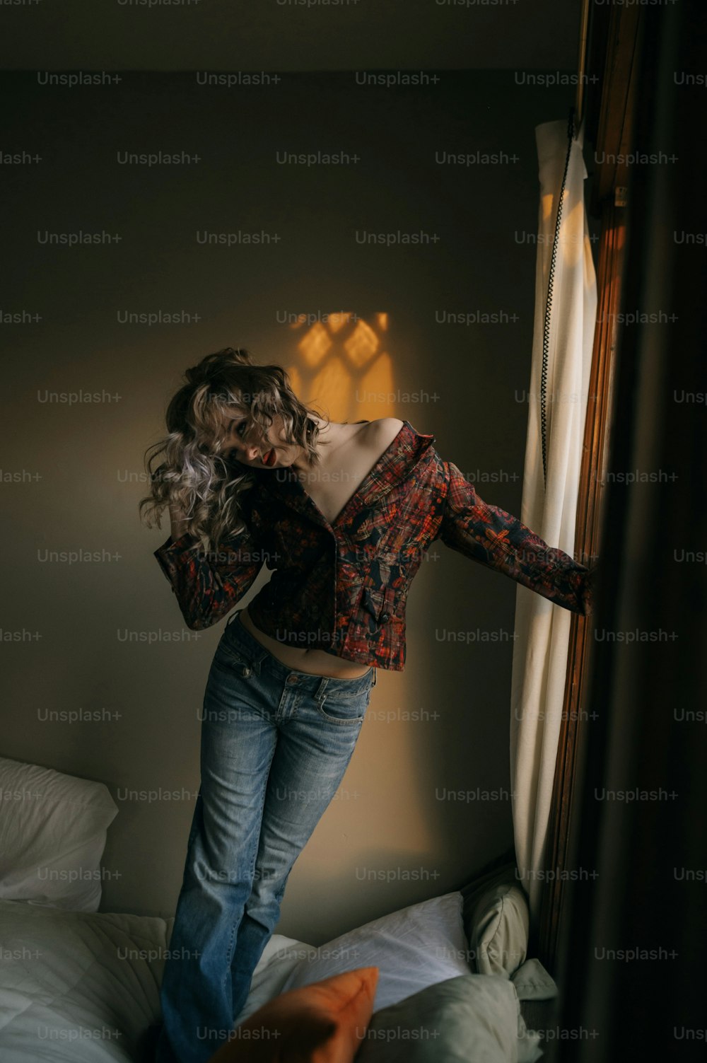 a woman standing on a bed in a room