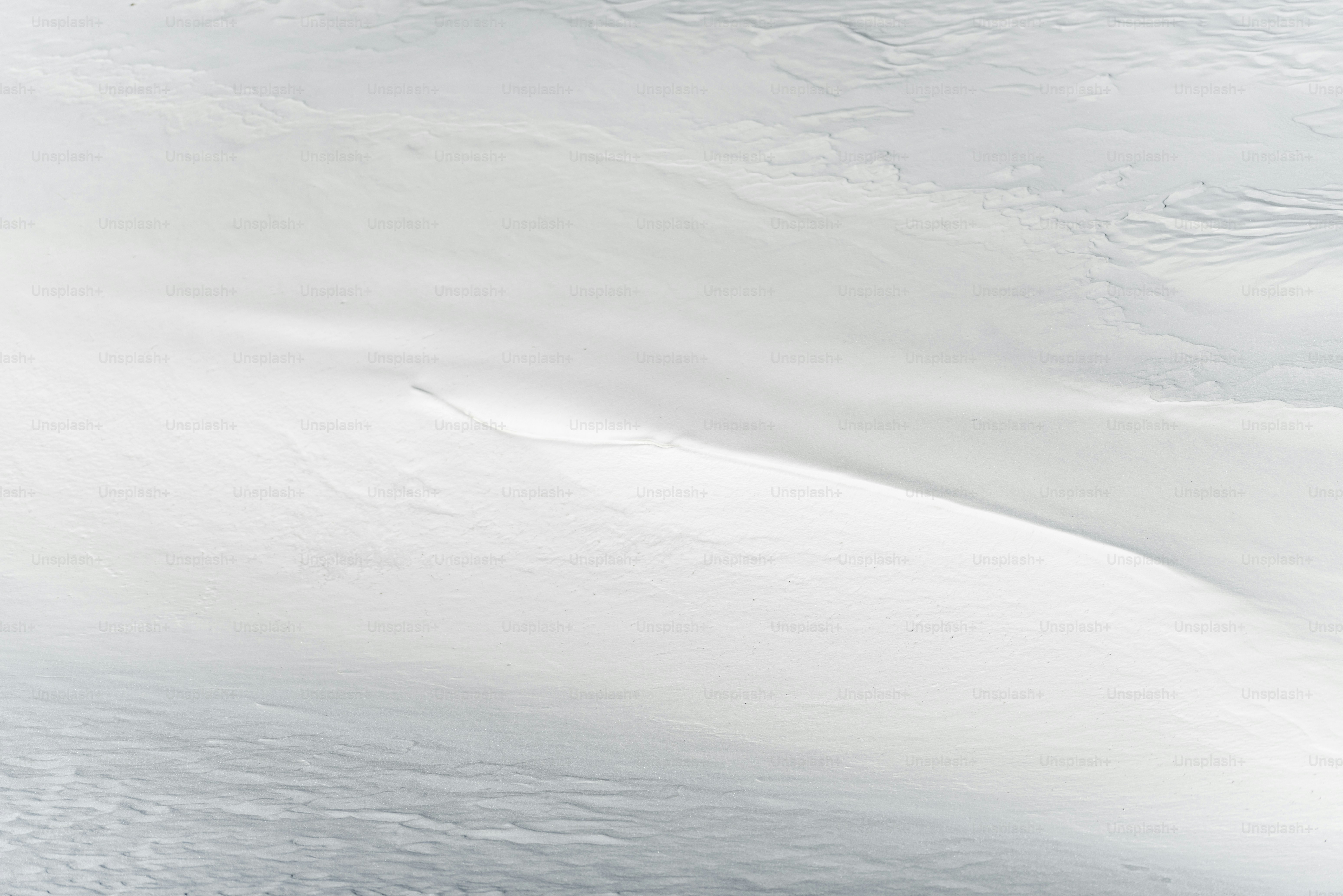 a man riding a snowboard down the side of a snow covered slope