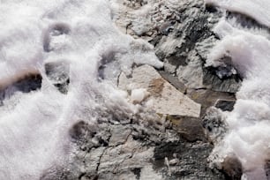 a rock covered in snow next to a pile of rocks