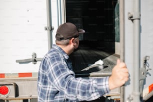 Ein Mann mit erhobenem Daumen vor einem Lastwagen