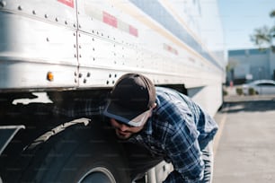 Un hombre apoyado en el costado de un camión grande