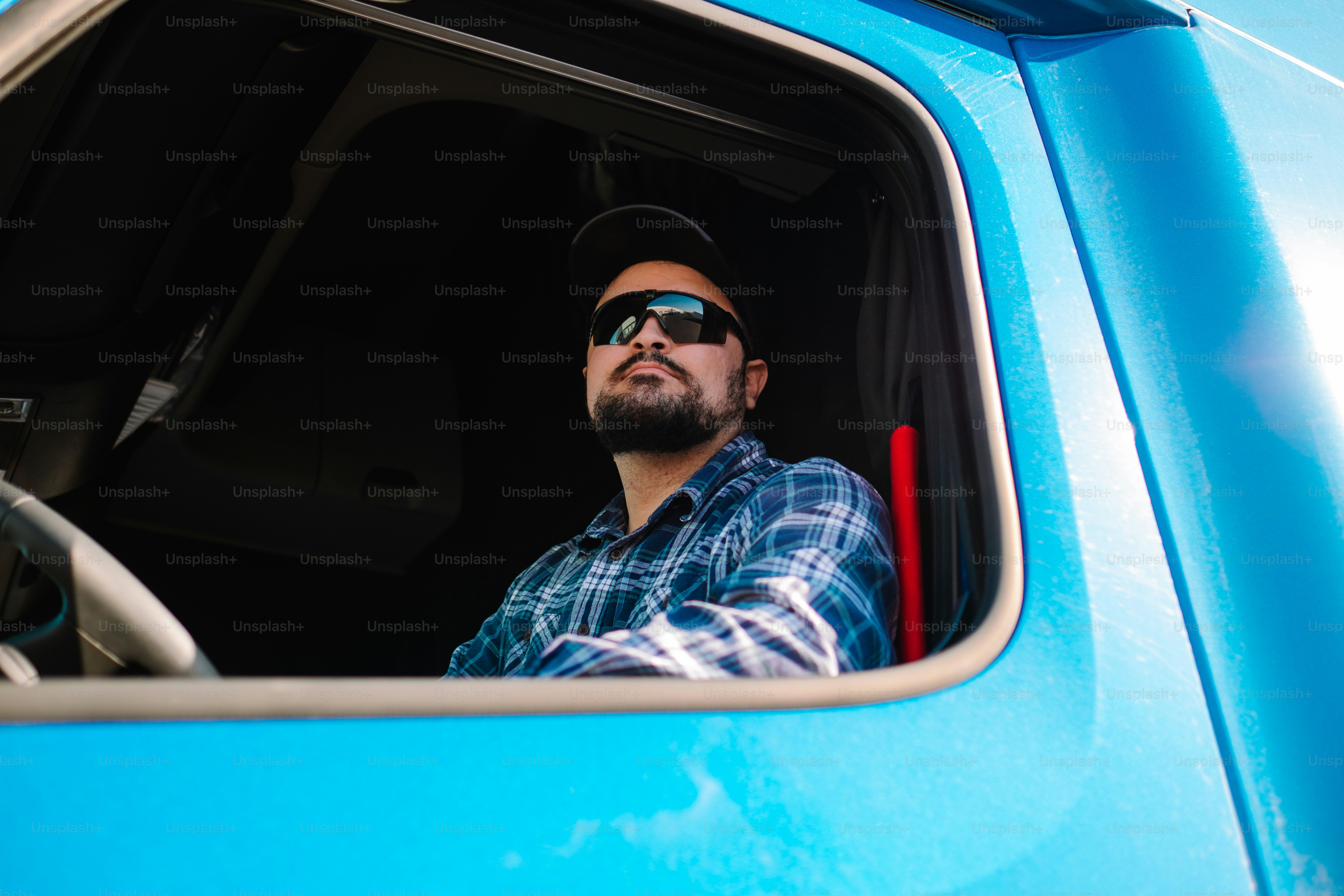 a man sitting in the drivers seat of a blue truck