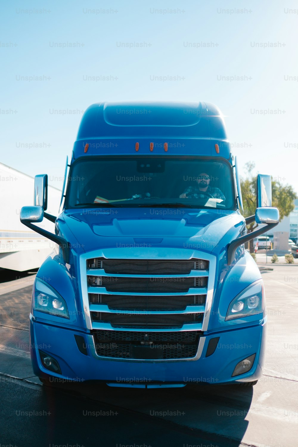 a blue semi truck driving down a street