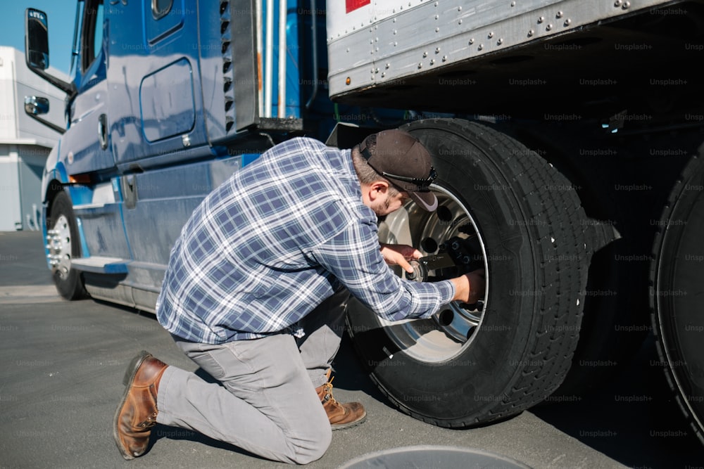 a man working on a tire on a semi truck