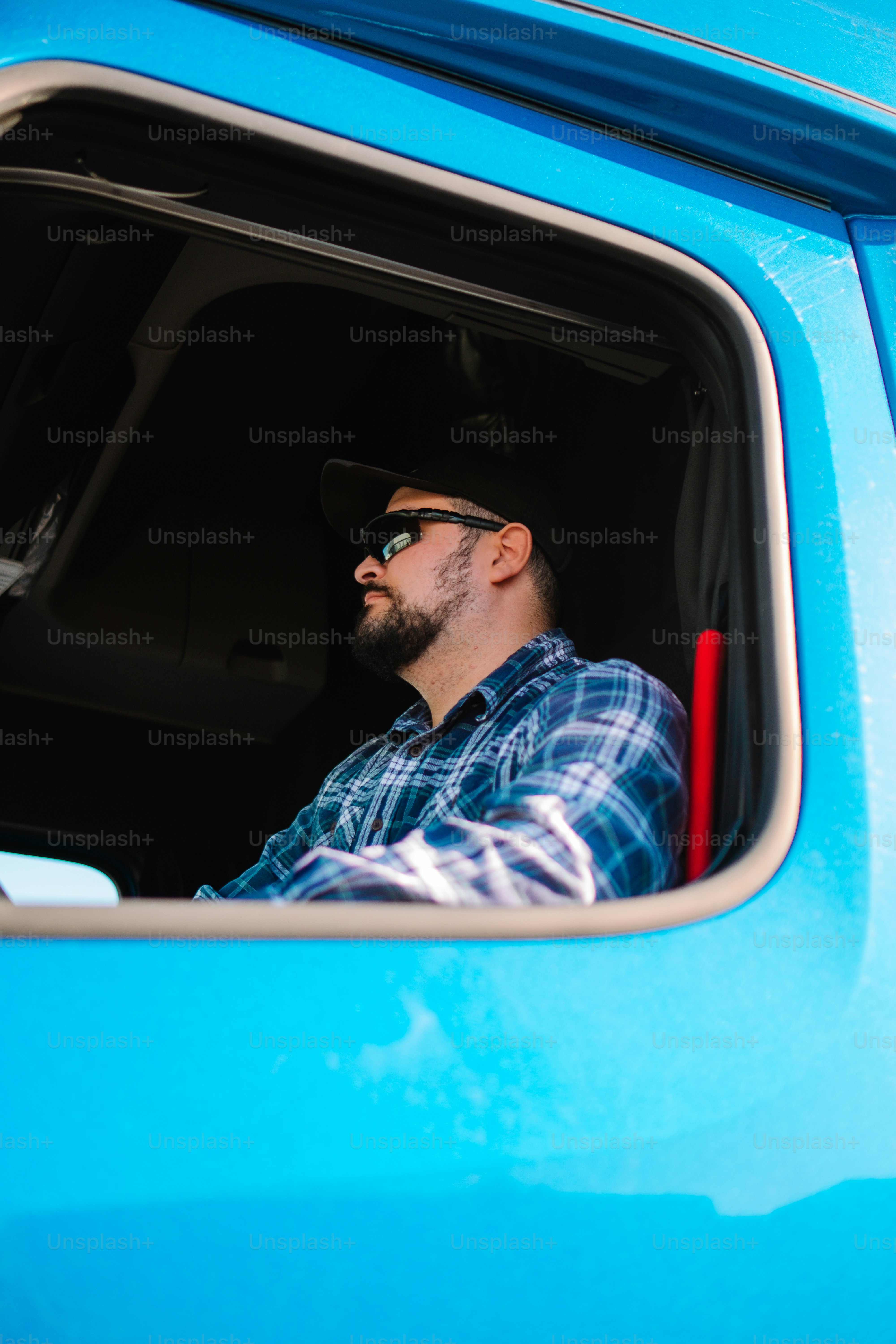 a man sitting in the drivers seat of a blue truck