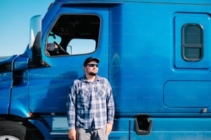 파란 트럭 앞에 서 있는 남자