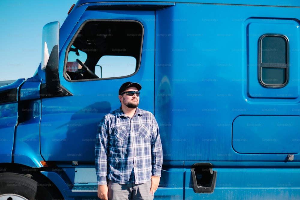 Ein Mann steht vor einem blauen Lastwagen