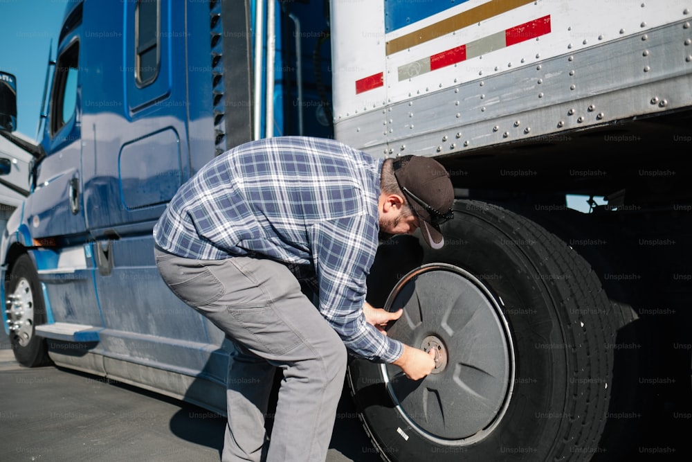 a man is changing the tire of a semi truck