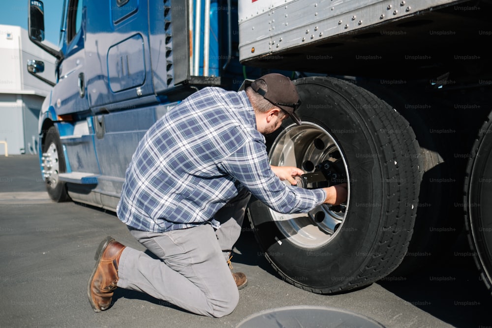 a man working on a tire on a semi truck