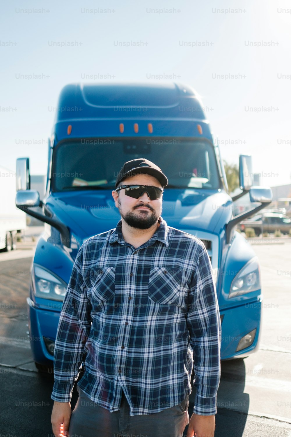 a man standing in front of a blue semi truck