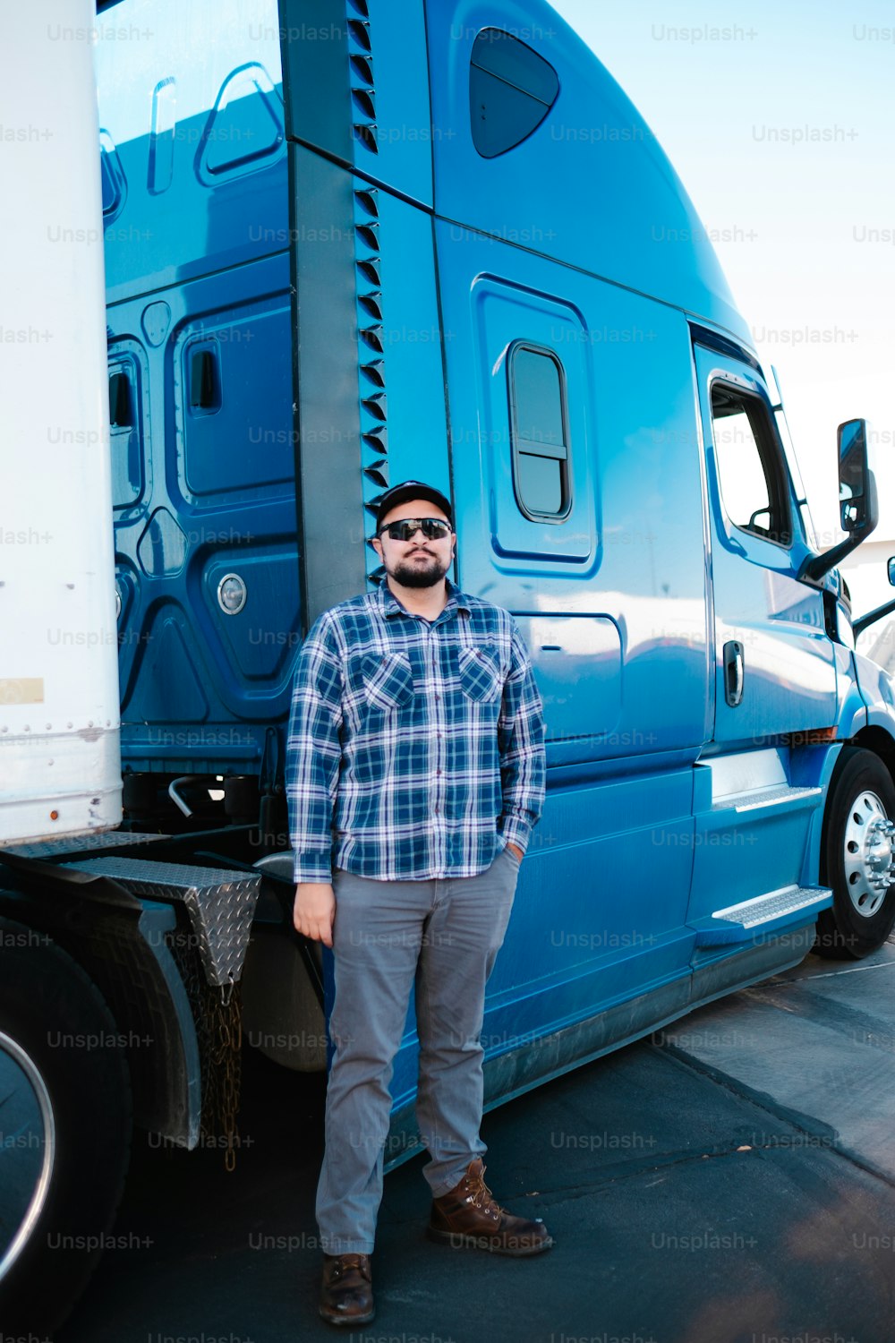 a man standing in front of a large blue truck