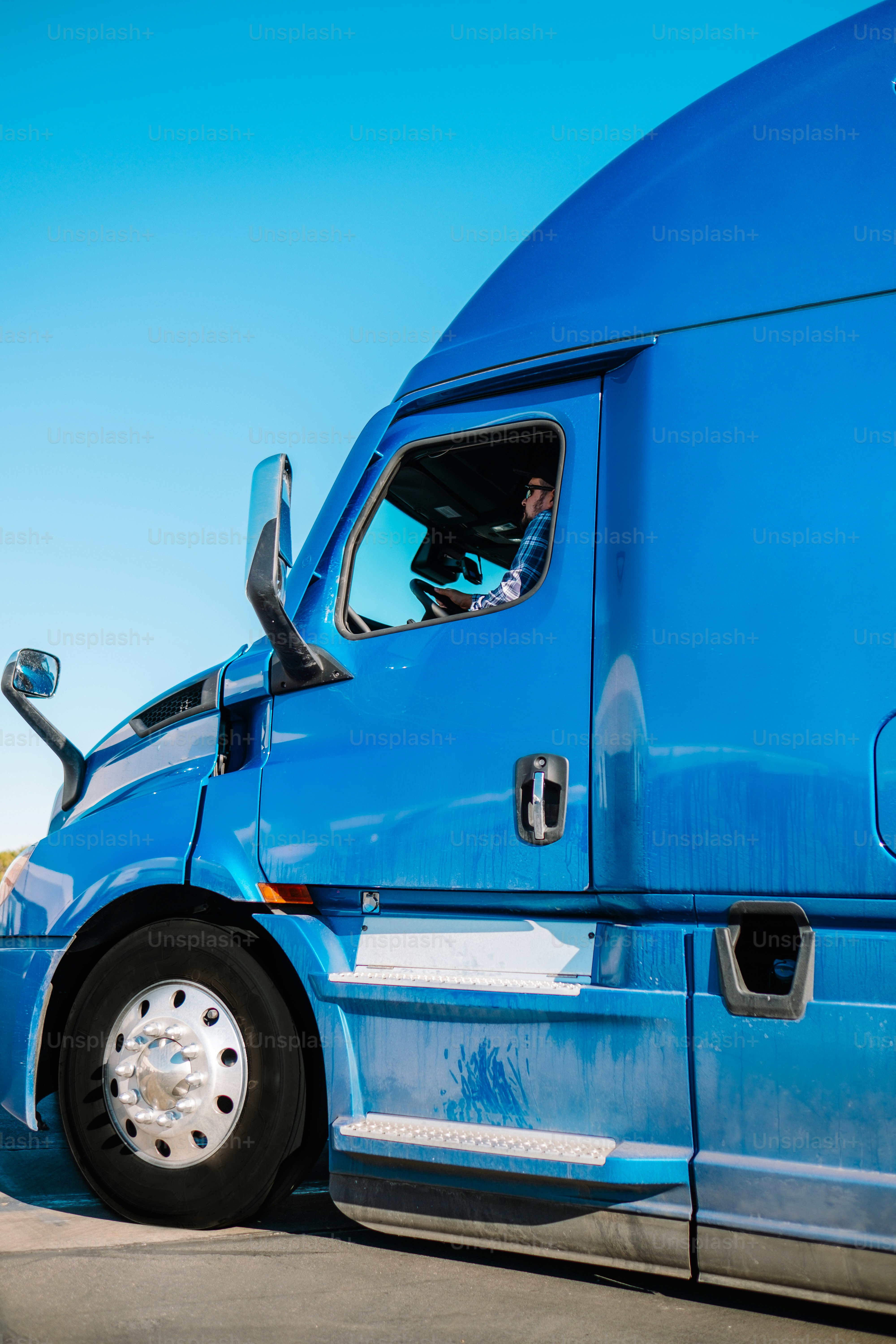 a blue semi truck parked in a parking lot