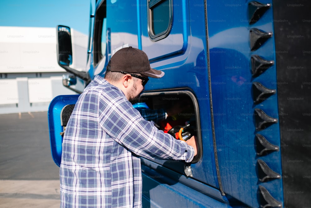 a man opening the door of a blue truck