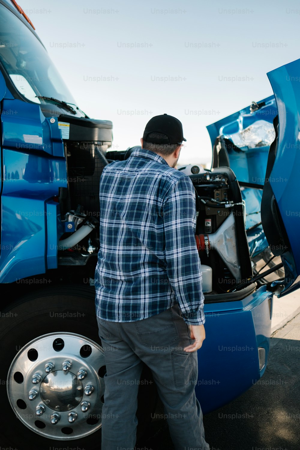 a man standing next to a blue semi truck