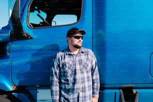 a man standing in front of a blue truck