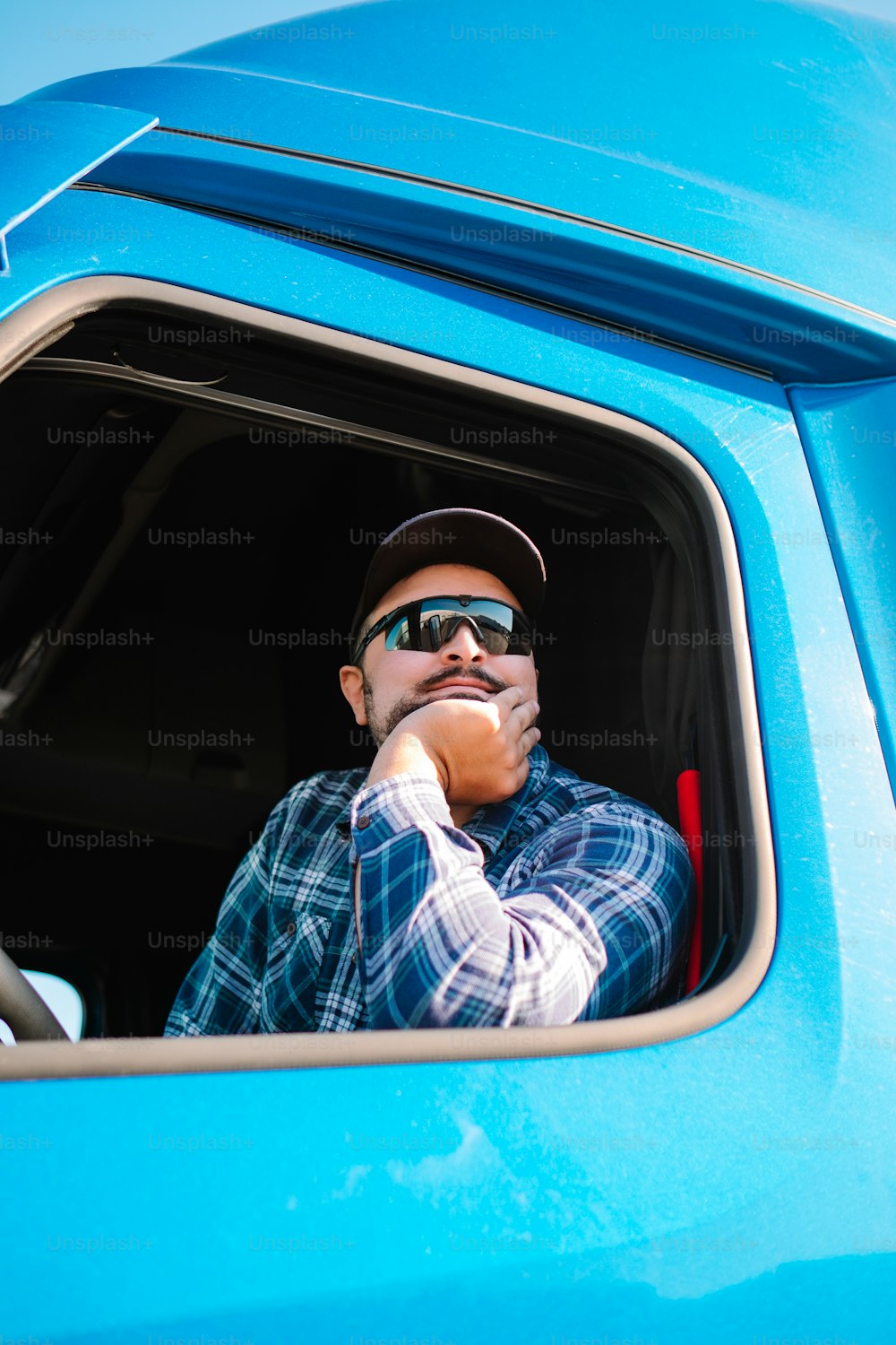 a man sitting in the drivers seat of a blue truck