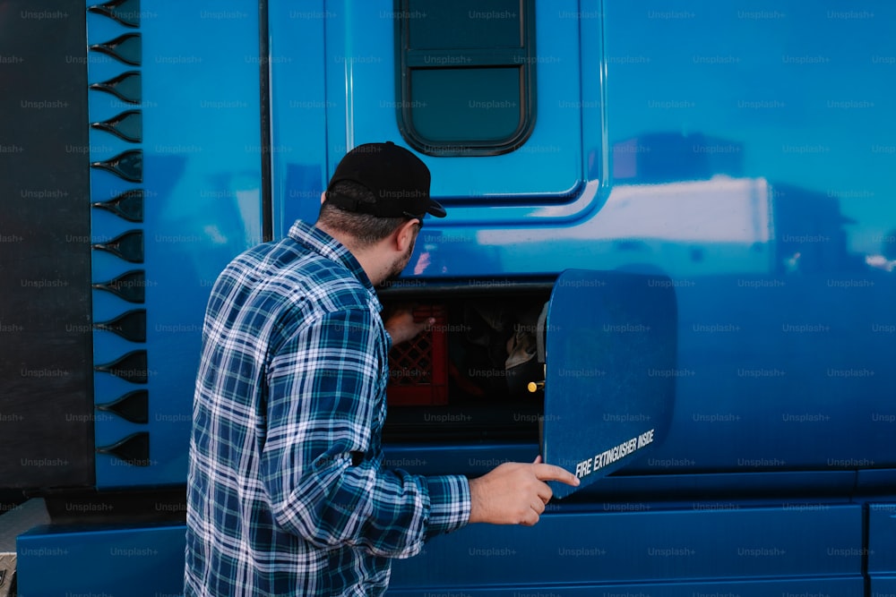 a man holding a paddle in front of a blue truck