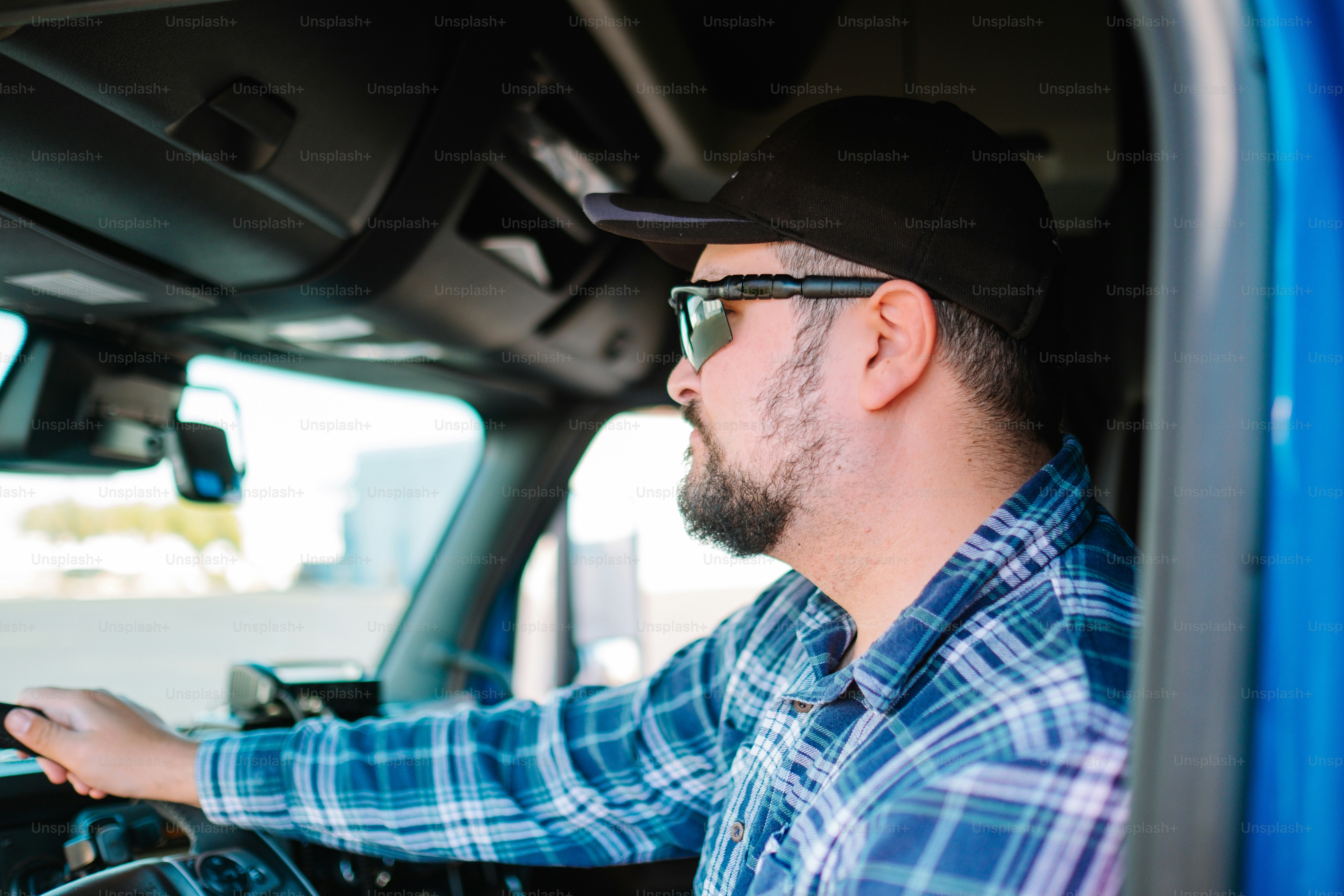 A man driving a truck wearing sunglasses and a hat photo Drive in