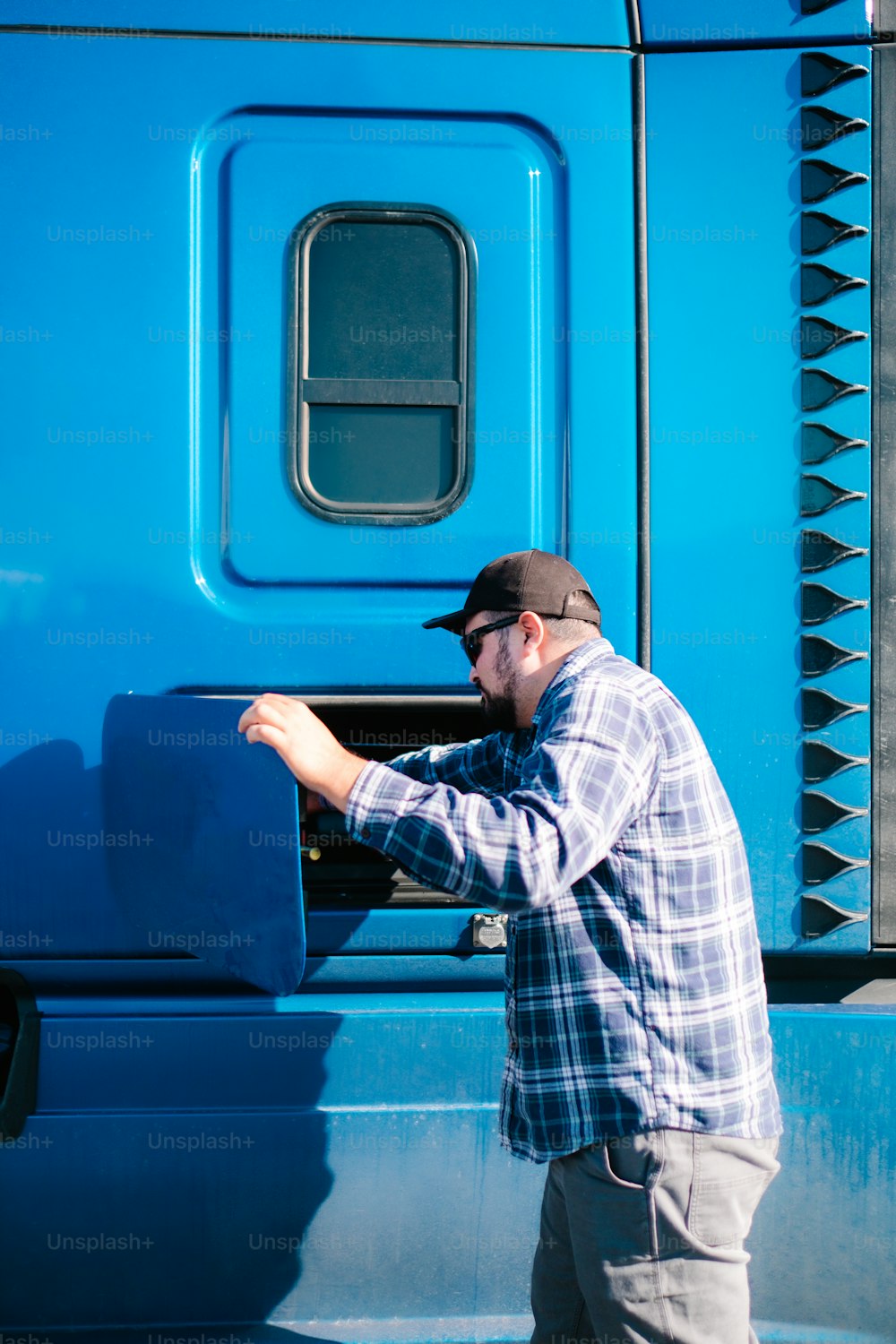 Un homme debout à côté d’un camion bleu