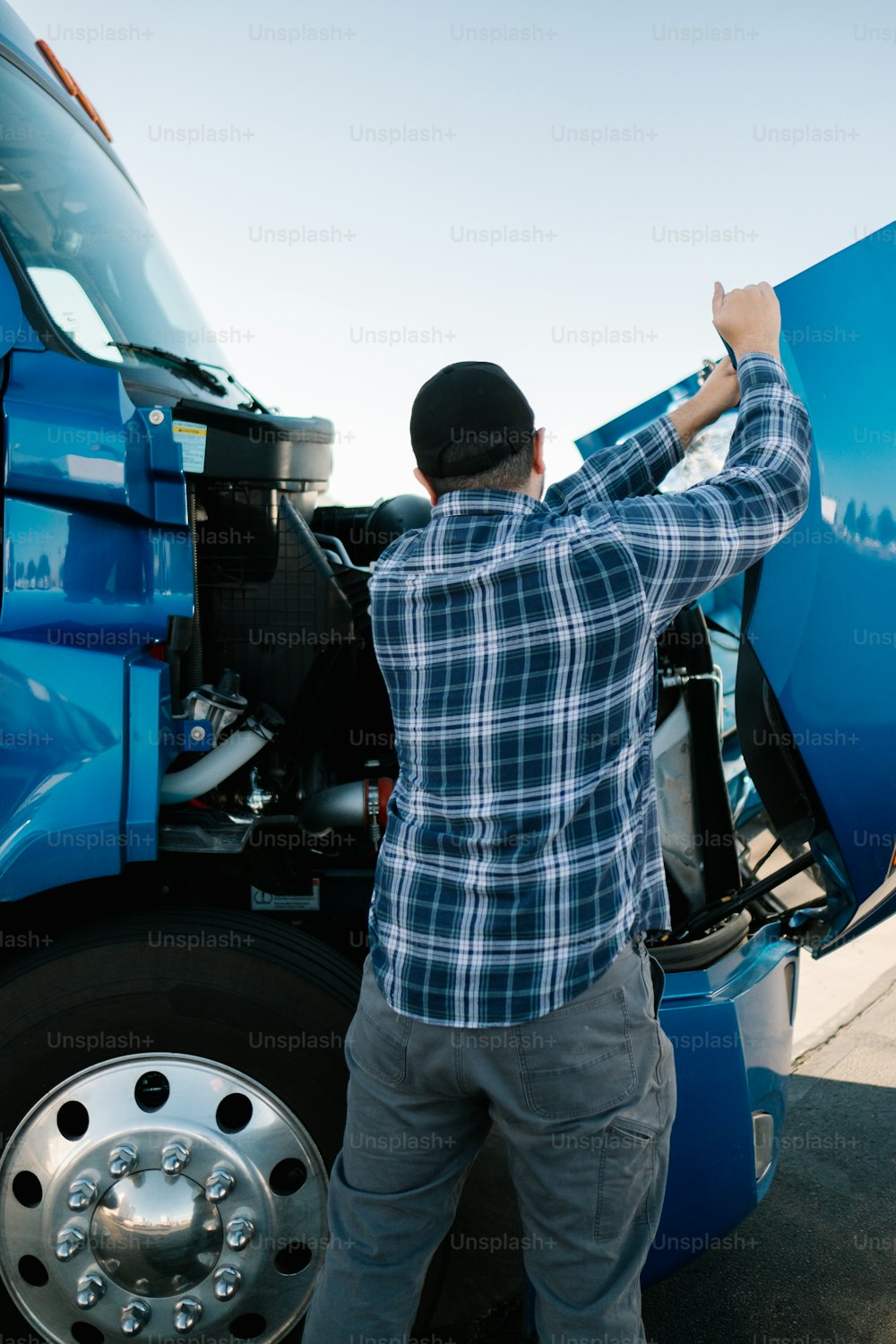 um homem de pé ao lado de um caminhão semi azul