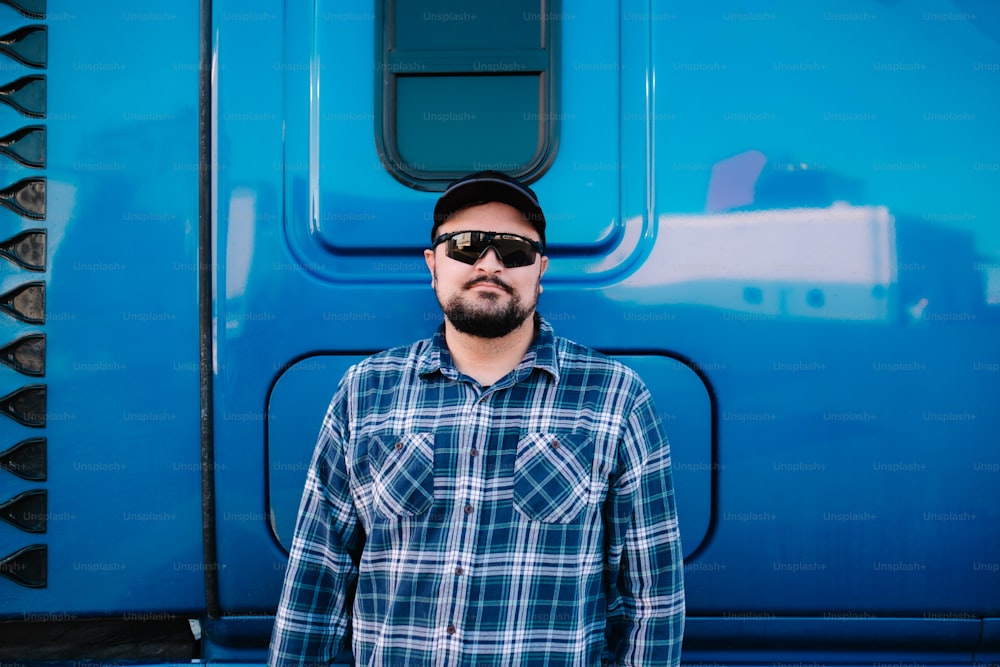 um homem em pé na frente de um caminhão azul