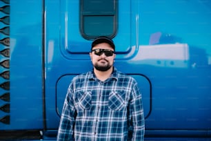 a man standing in front of a blue truck