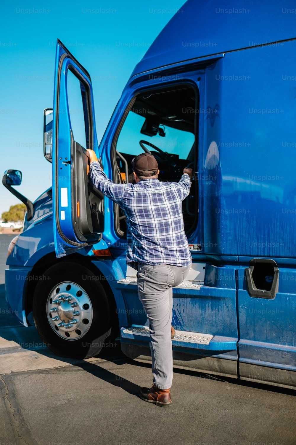 a man stepping out of a blue semi truck