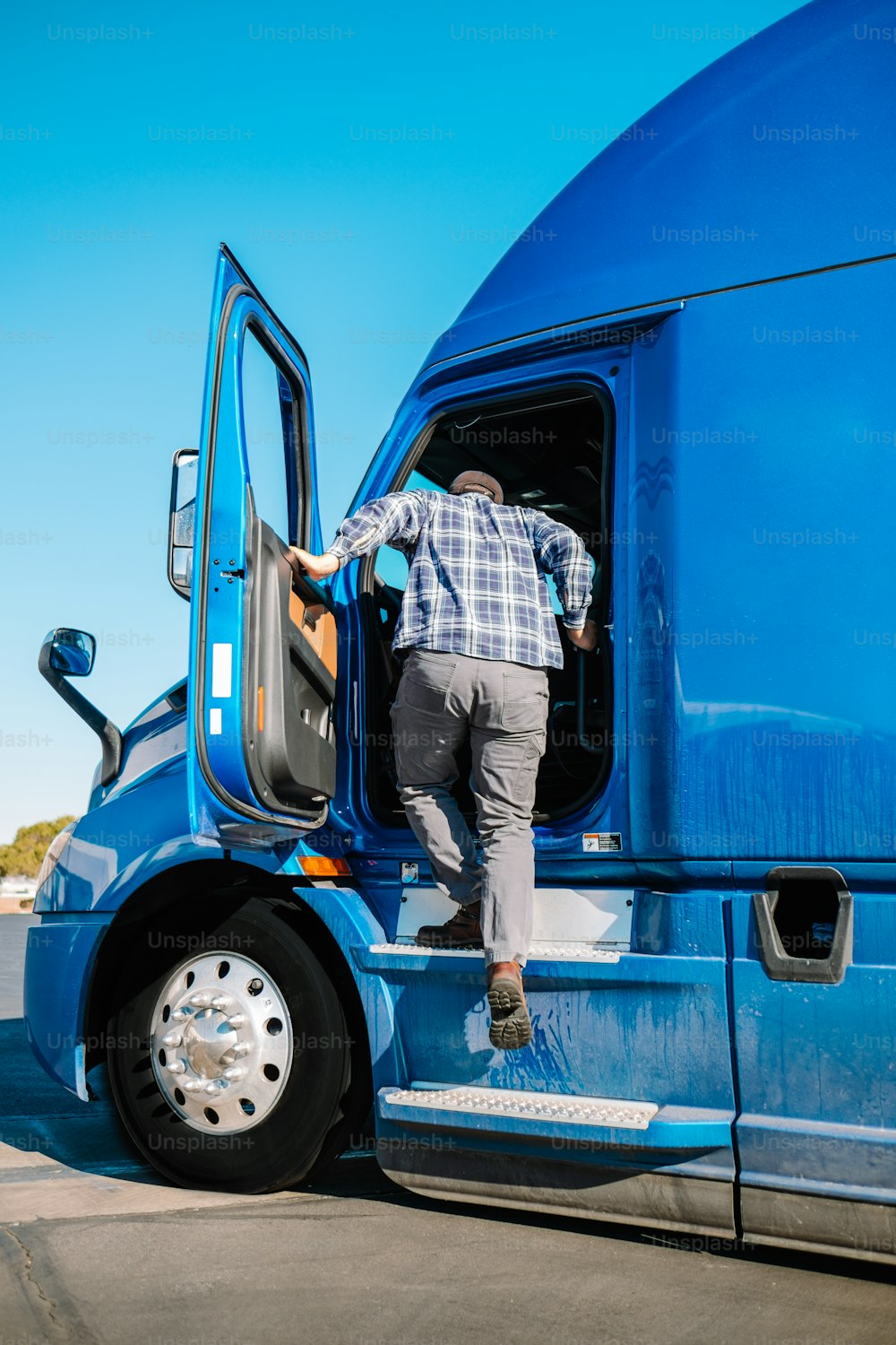 a man stepping out of a blue semi truck