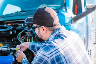 a man working on a vehicle with a wrench