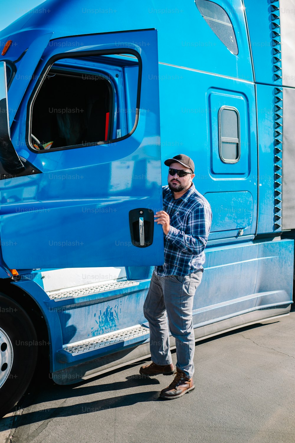 Ein Mann steht neben einem großen blauen Lastwagen