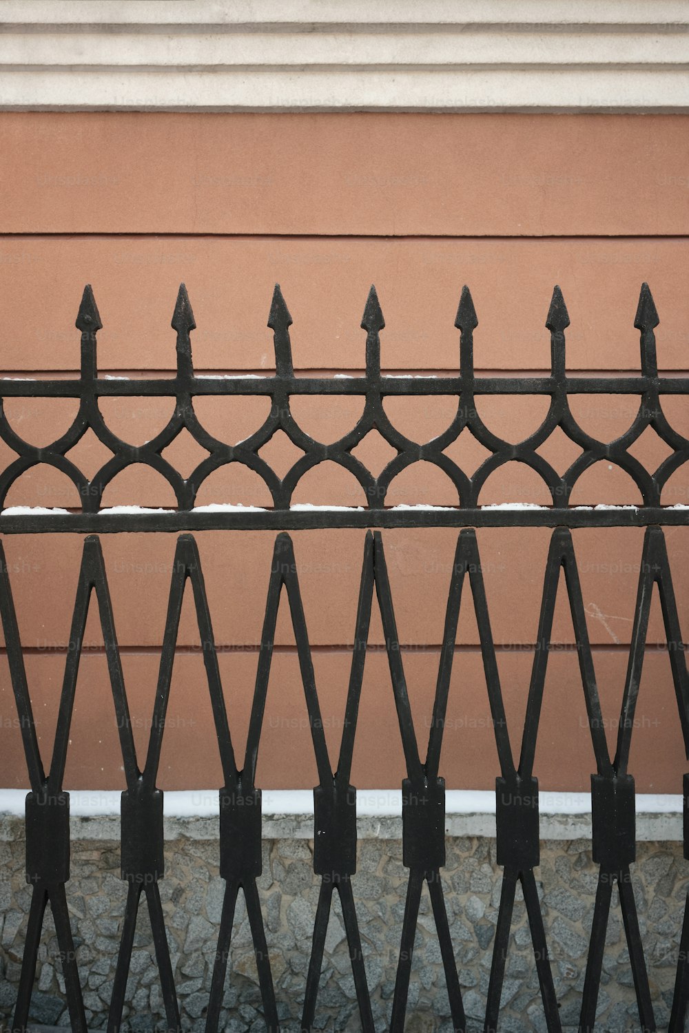 a close up of a metal fence with a building in the background