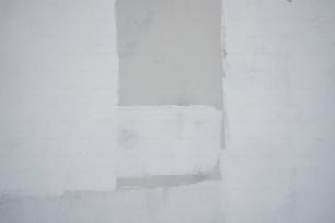 una pared blanca con un reloj en blanco y negro