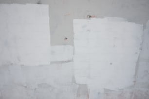 Un idrante rosso seduto accanto a un muro bianco