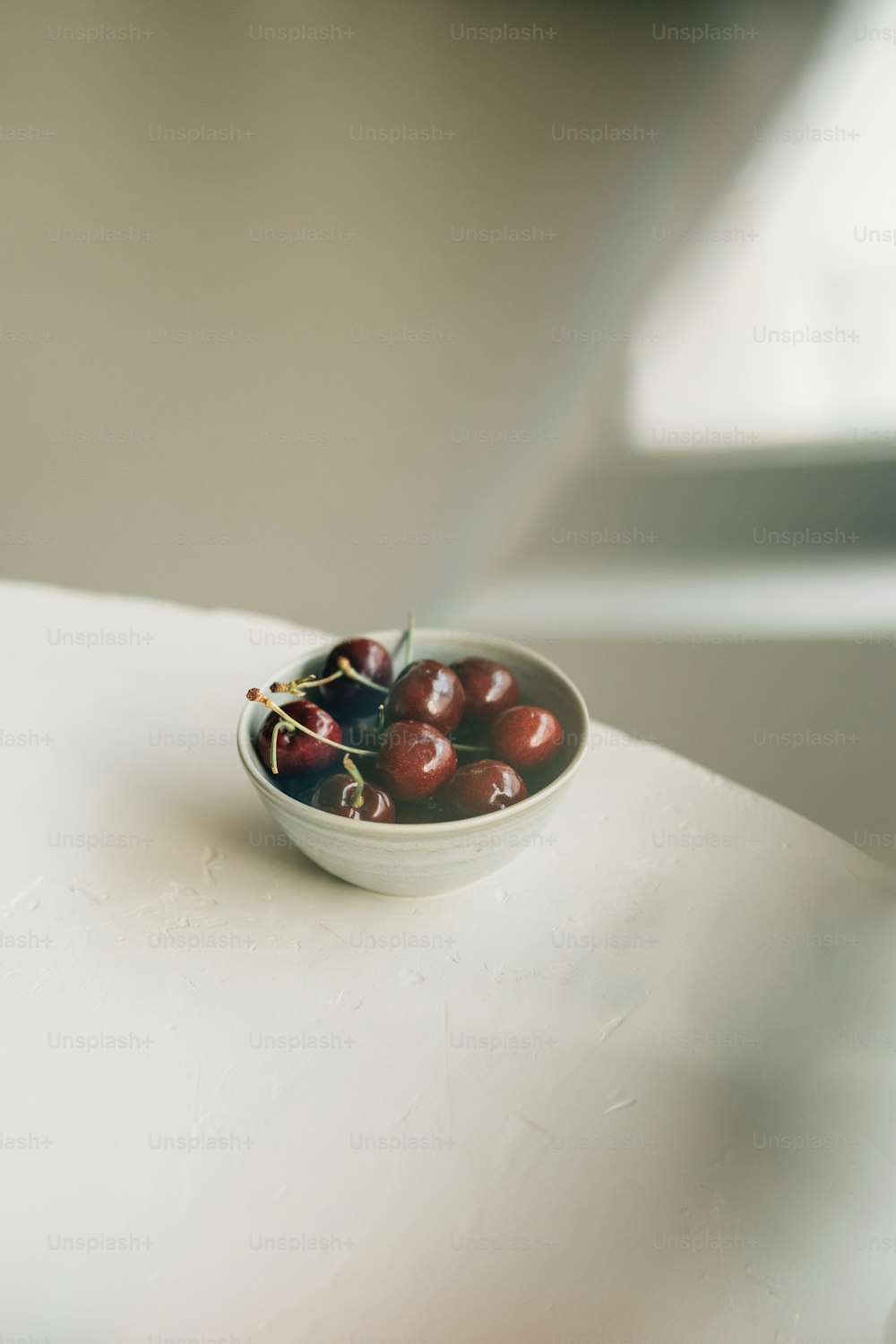 a bowl of cherries sitting on a table