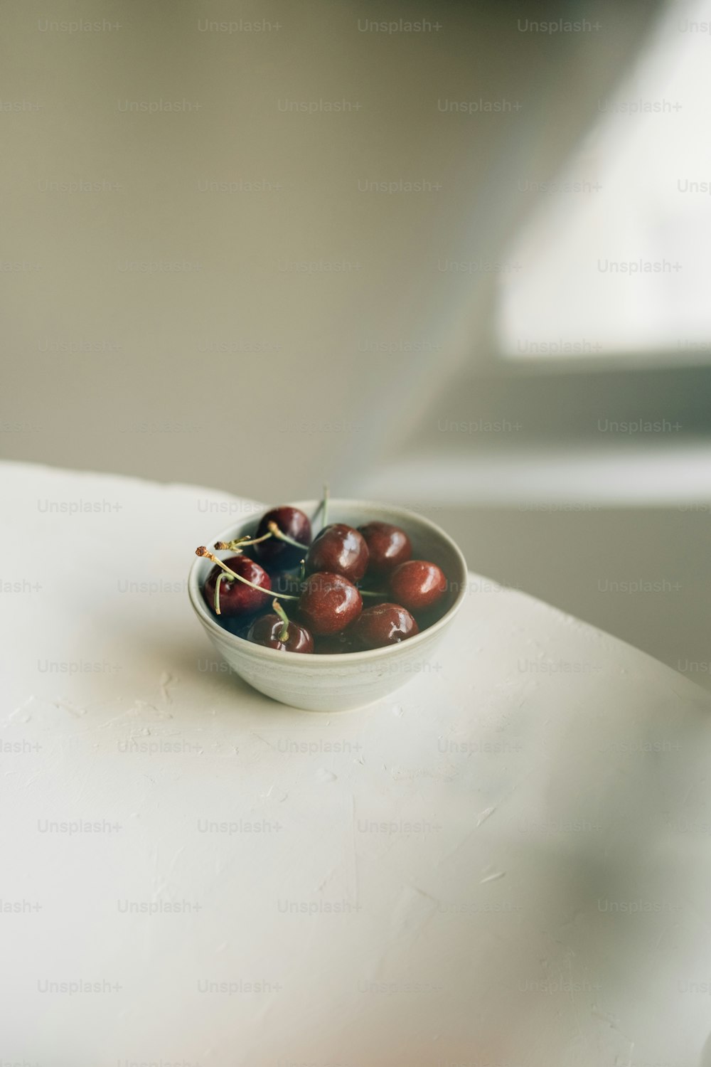 un bol de cerises posé sur une table