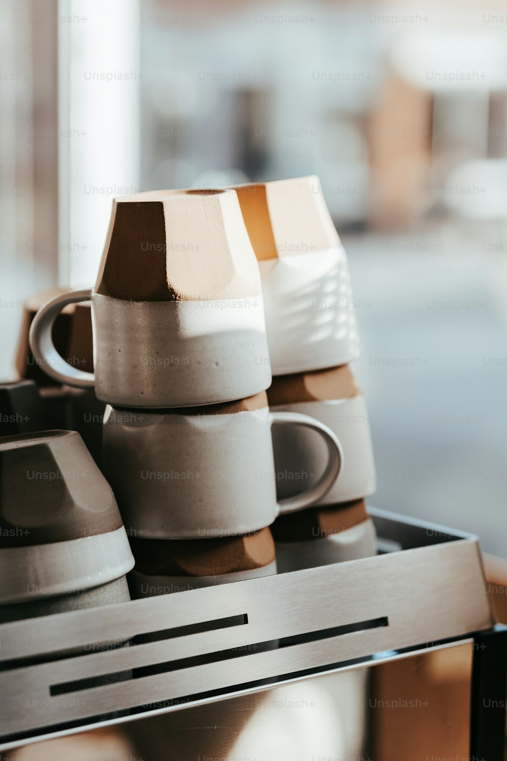 a stack of coffee cups sitting on top of a metal shelf