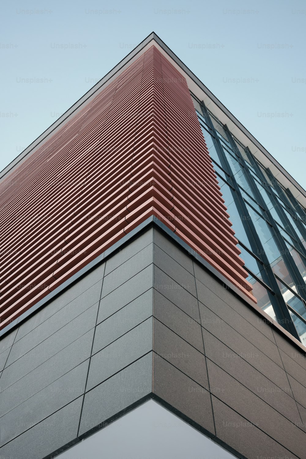 Un grand bâtiment avec une bande rouge et noire sur le côté