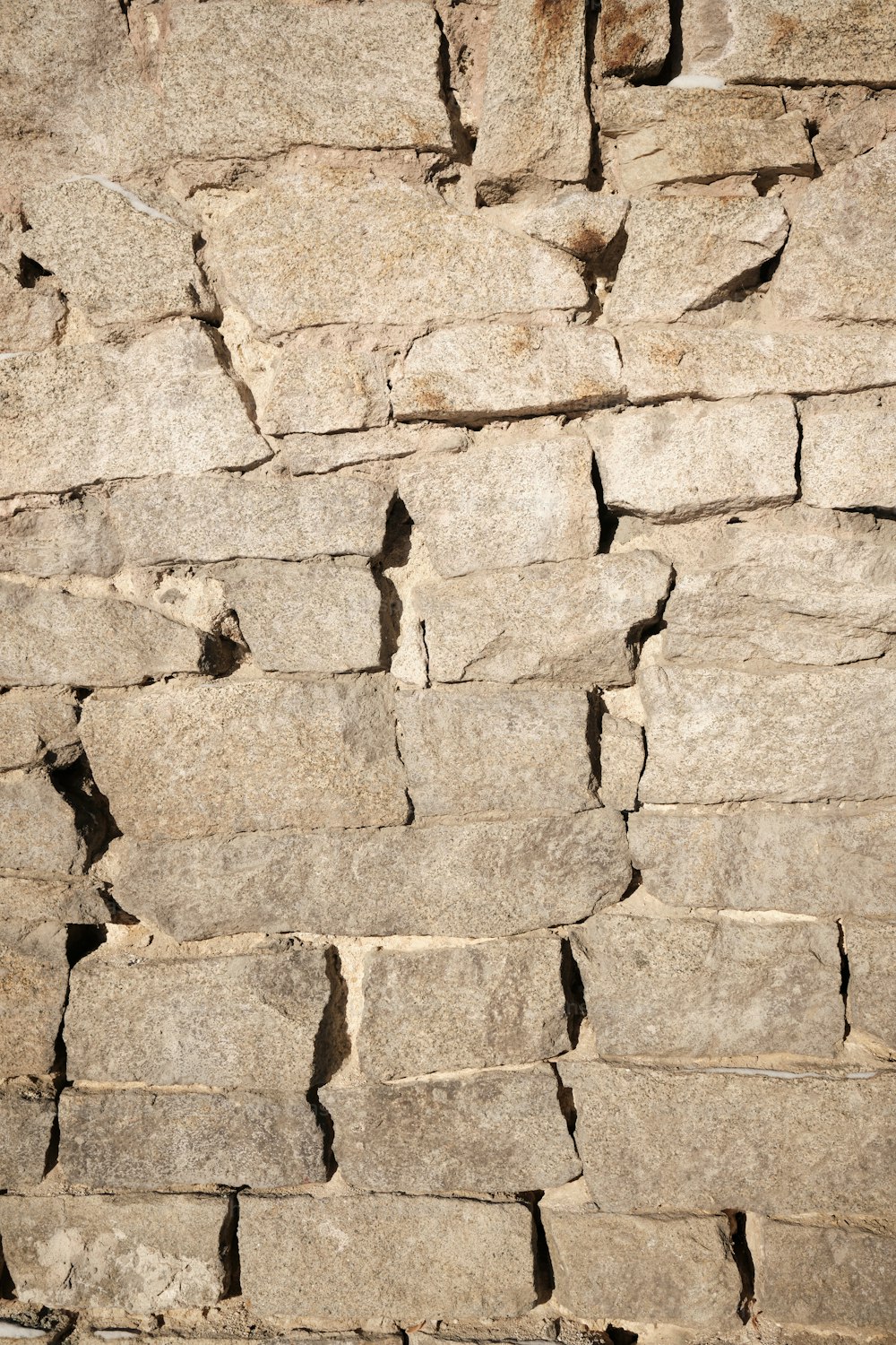 a stone wall with cracks in it