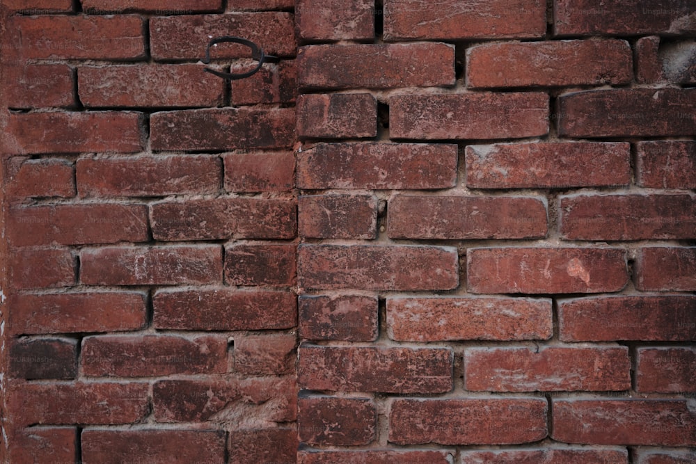 eine rote Backsteinmauer mit einer Uhr darauf