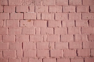 a red brick wall with a small patch of paint on it