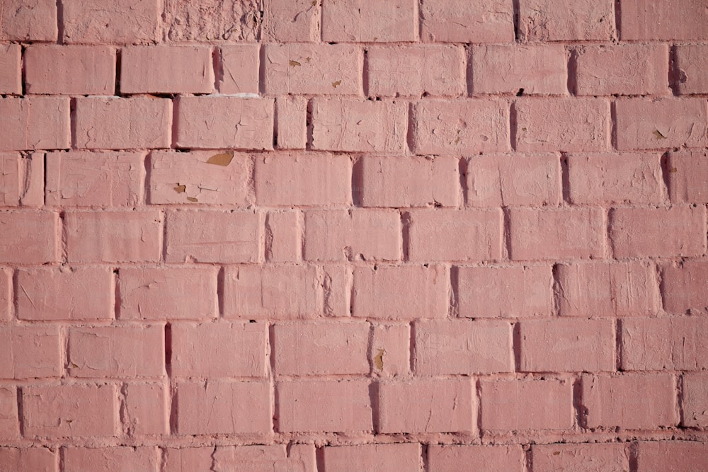 a red brick wall with a small patch of paint on it