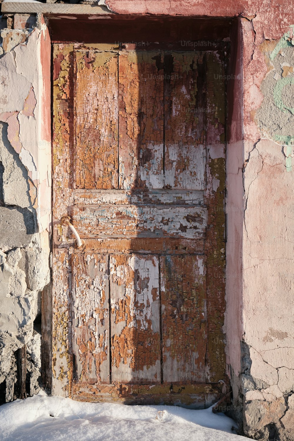 una vecchia porta di legno con vernice scrostata su di essa
