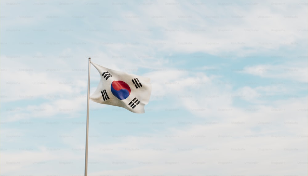a korean flag flying in the wind on a cloudy day