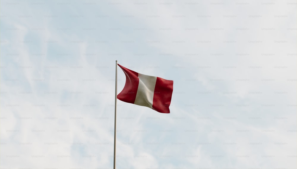 a red and white flag flying in the sky