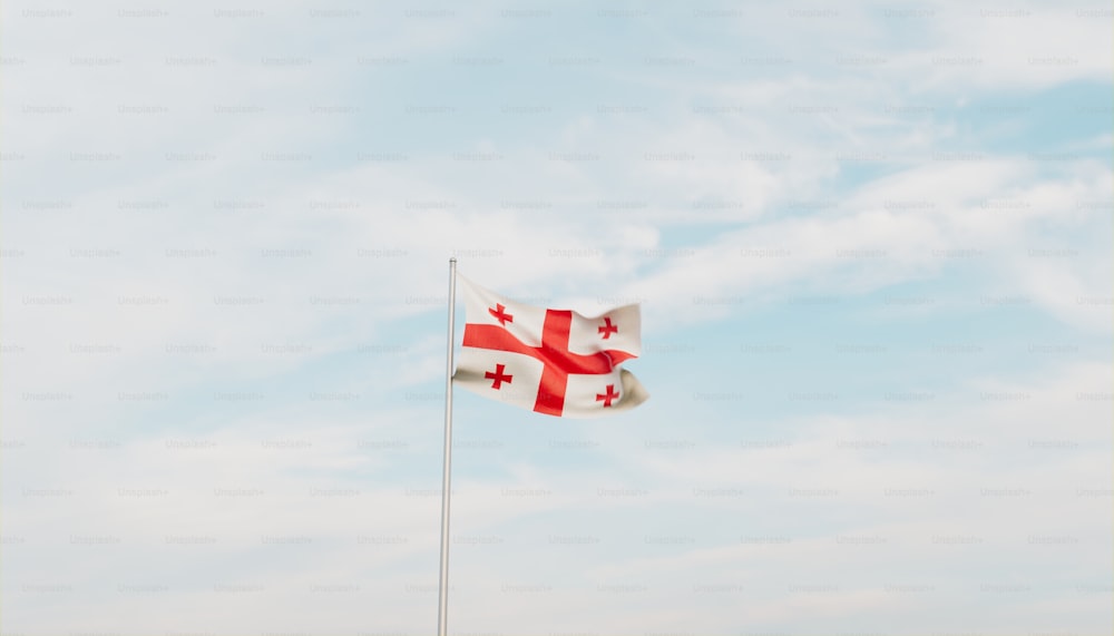 a flag flying in the wind with a blue sky in the background