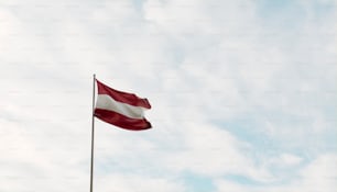 a red and white flag flying in the sky