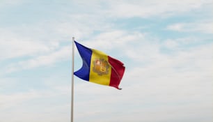 a flag flying in the wind with a blue sky in the background